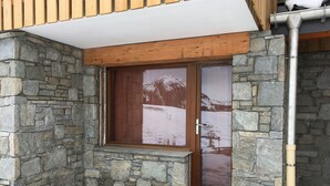 A stone-walled building with a wooden window and a metal gutter. - Cosy studio in Plagne Villages at the foot of the slopes (PLAGNE VILLAGE)