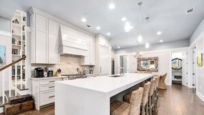 A spacious kitchen with a large island, white cabinetry, and a modern design. - Shared Amenities w/ LSV and Screened Porch (Santa Rosa Beach)