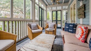 A covered porch with wicker furniture, a wooden table, and a cushioned sofa. - Shared Amenities w/ LSV and Screened Porch (Santa Rosa Beach)