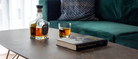 Un livre intitulé « Marilyn à Manhattan » et une bouteille de whisky sur une table.