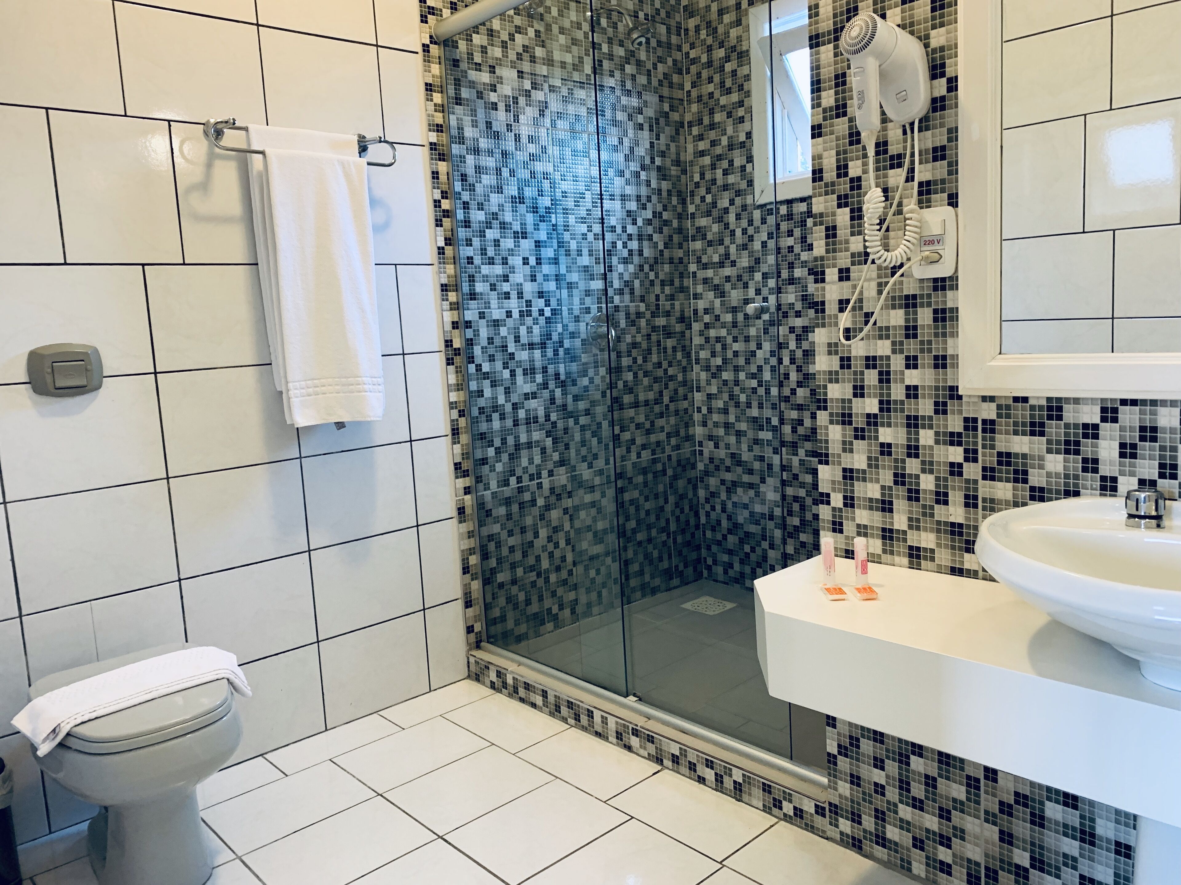 Un baño con ducha, inodoro y lavamanos.