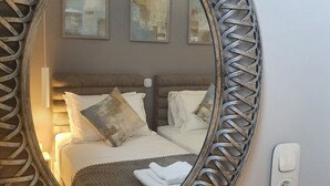 A bedroom with a large ornate mirror, a bed with white linens, and two abstract paintings on the wall. - NEW Villa Sheila with private pool and BBQ. (Rethymno, Crete)