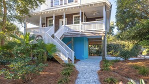 A two-story house with a covered porch and a staircase leading to the upper level. - Prince's Folly! Walking Distance to Shops and Restaurants! (Folly Beach)
