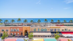 Une ville côtière avec des bâtiments, des palmiers et une vue sur la mer.