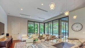 Un interior moderno con cocina, zona de estar y ventanas grandes.