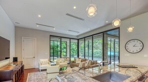 A modern interior with a kitchen, seating area, and large windows.