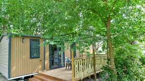A wooden cabin with a deck and a covered patio area. - Domaine Les Rousselieres (Les Sables-d'Olonne)