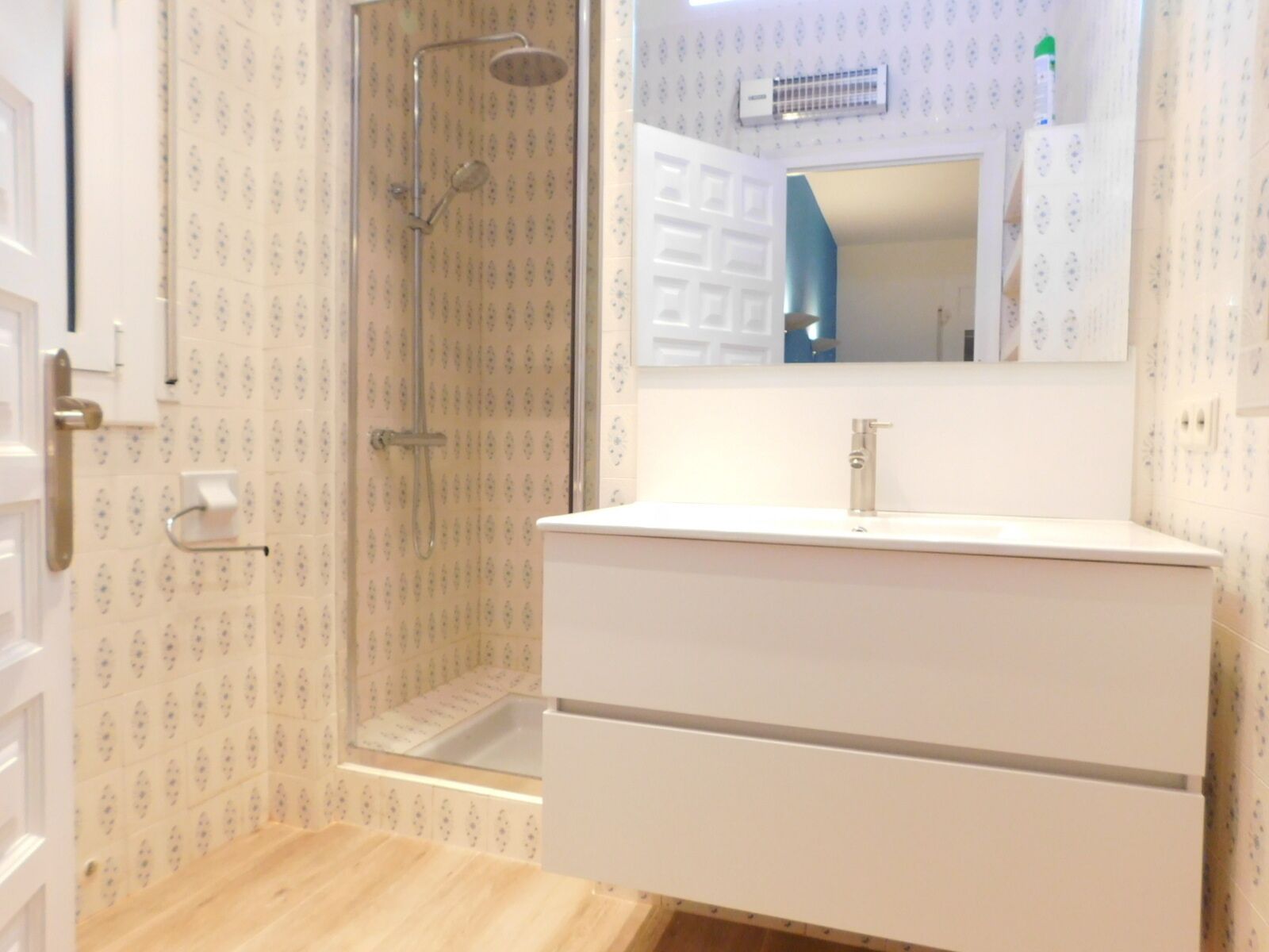 Une salle de bain avec une douche, un lavabo et un miroir.