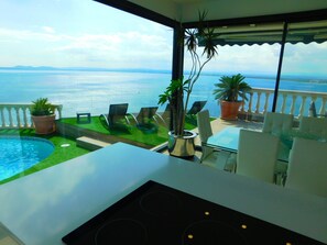 En balkon med havudsigt, en pool og udendørs møbler.