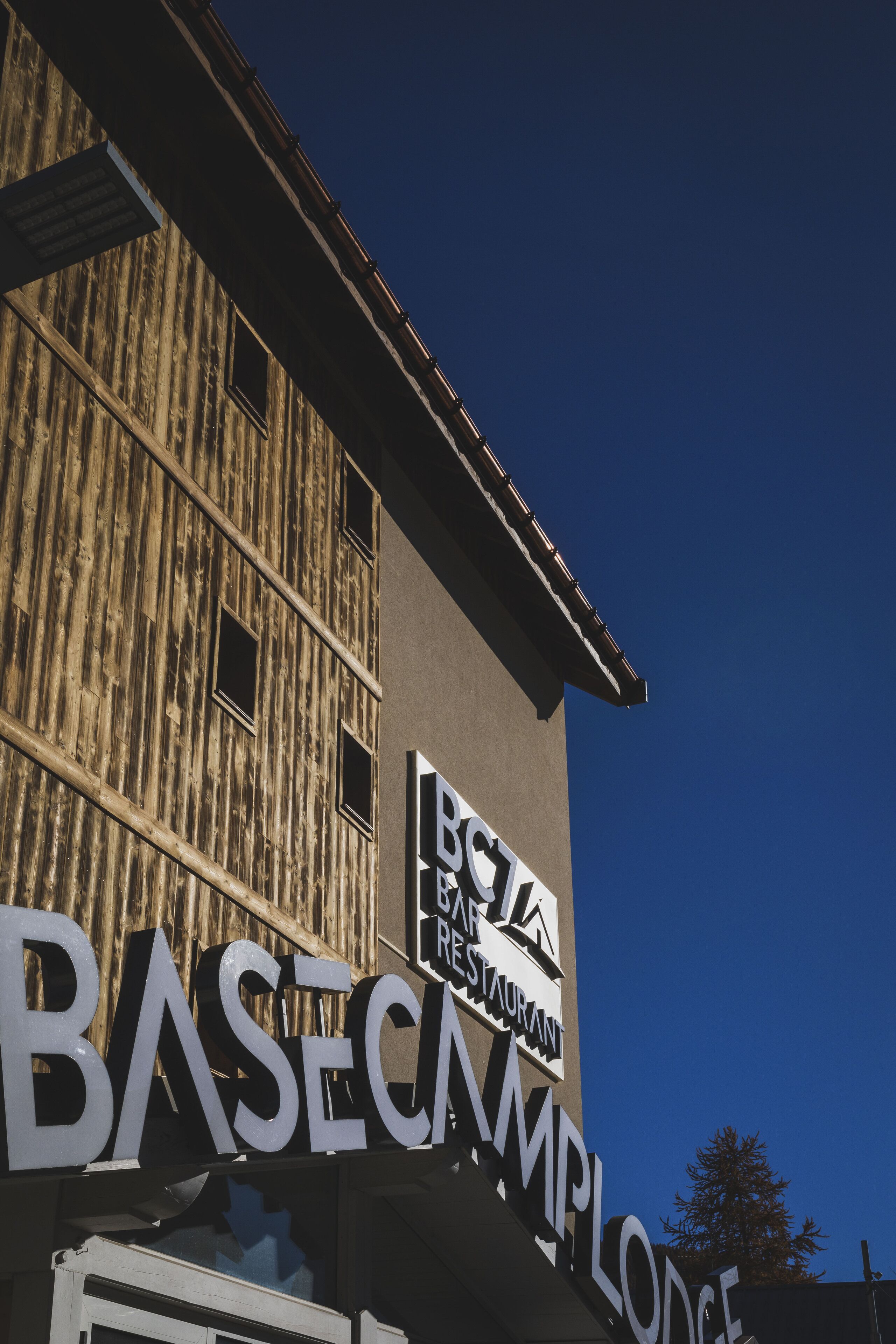 A building with a sign that reads "BASECAMP RESTAURANT" and "BASECAMP LODGE".