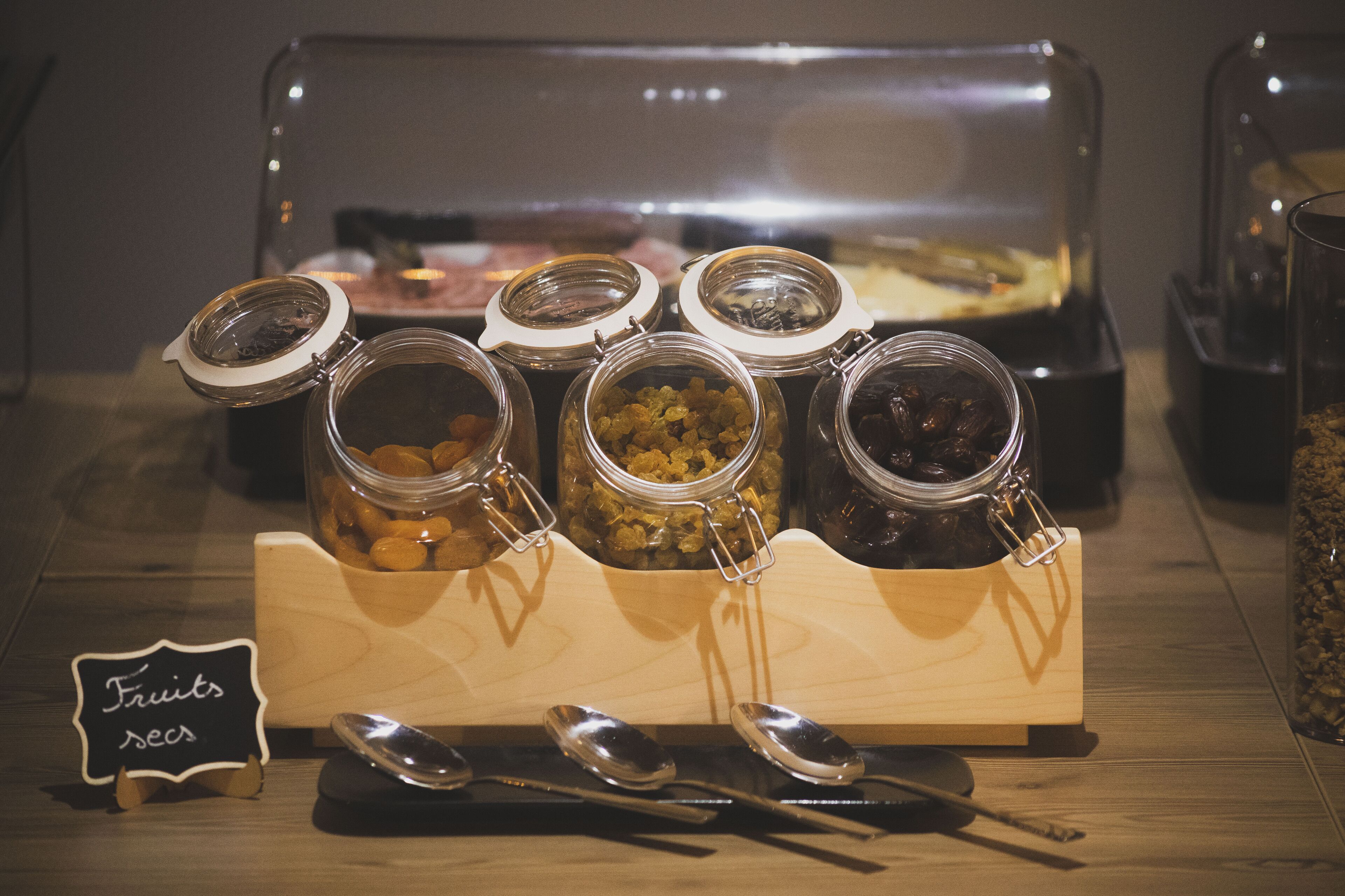 A buffet setup with various food items in jars and a sign indicating 'Fruits & Veggies'.