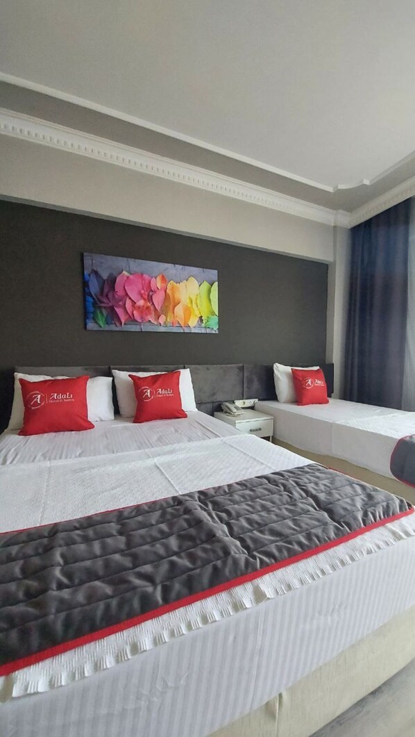 Habitación de hotel con dos camas, un cuadro grande en la pared y vistas al exterior.