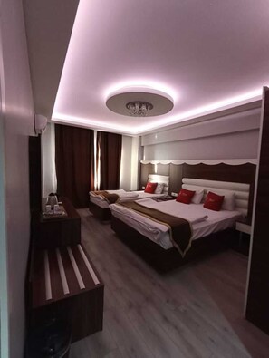 A hotel room with two beds, a desk, and a vanity.