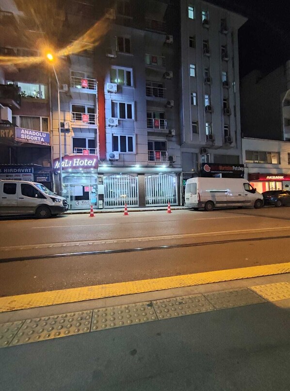 A hotel with a gated entrance, multiple floors, and a visible sign for 'Anadoluhisigorta'.