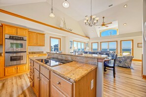 A spacious kitchen with wooden cabinets, stainless steel appliances, and a large island.