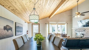 A conference room with a long table, chairs, a plant, and a fireplace.