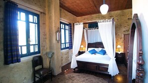 A bedroom with a wooden ceiling, a four-poster bed with white bedding, a chair, and a bedside table with a lamp. - ★ Only for 2 ★ cosy stone villa, totally private, pool, near sea, WiFi, parking (Chania)