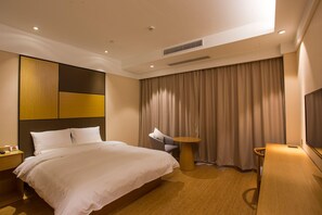 A modern hotel room with a large bed, a desk, and a chair. - Ji Hotel (Shanghai)