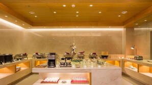 A modern, well-lit kitchen area with marble countertops, a coffee machine, and various food items. - Ji Hotel (Shanghai)