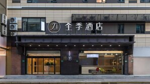 A hotel entrance with a modern design, featuring a prominent logo and signage. - Ji Hotel (Shanghai)