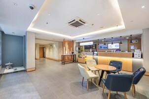 Un interior de cafetería moderna con mostrador, zona de estar y detalles decorativos.