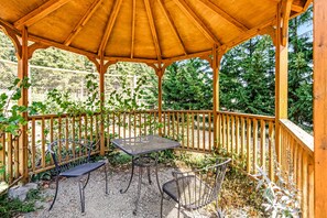 A wooden gazebo with a table and chairs, surrounded by a wooden fence and greenery. - Quilcene ground-floor studio with mountain views & fast WiFi - dog-friendly (Quilcene)