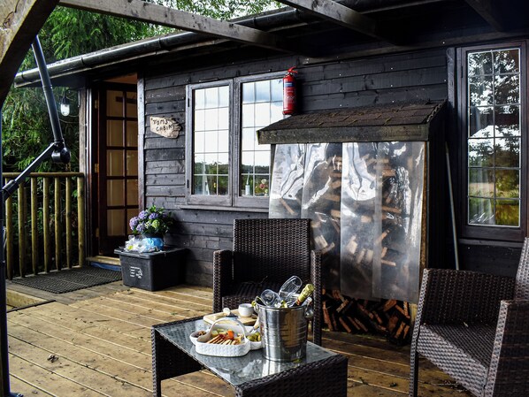 A wooden cabin with a deck, a fire pit, outdoor seating, and a sign reading "TOM'S CABIN". - Toms Cabin - UK35173 (Stelling Minnis, near Canterbury)