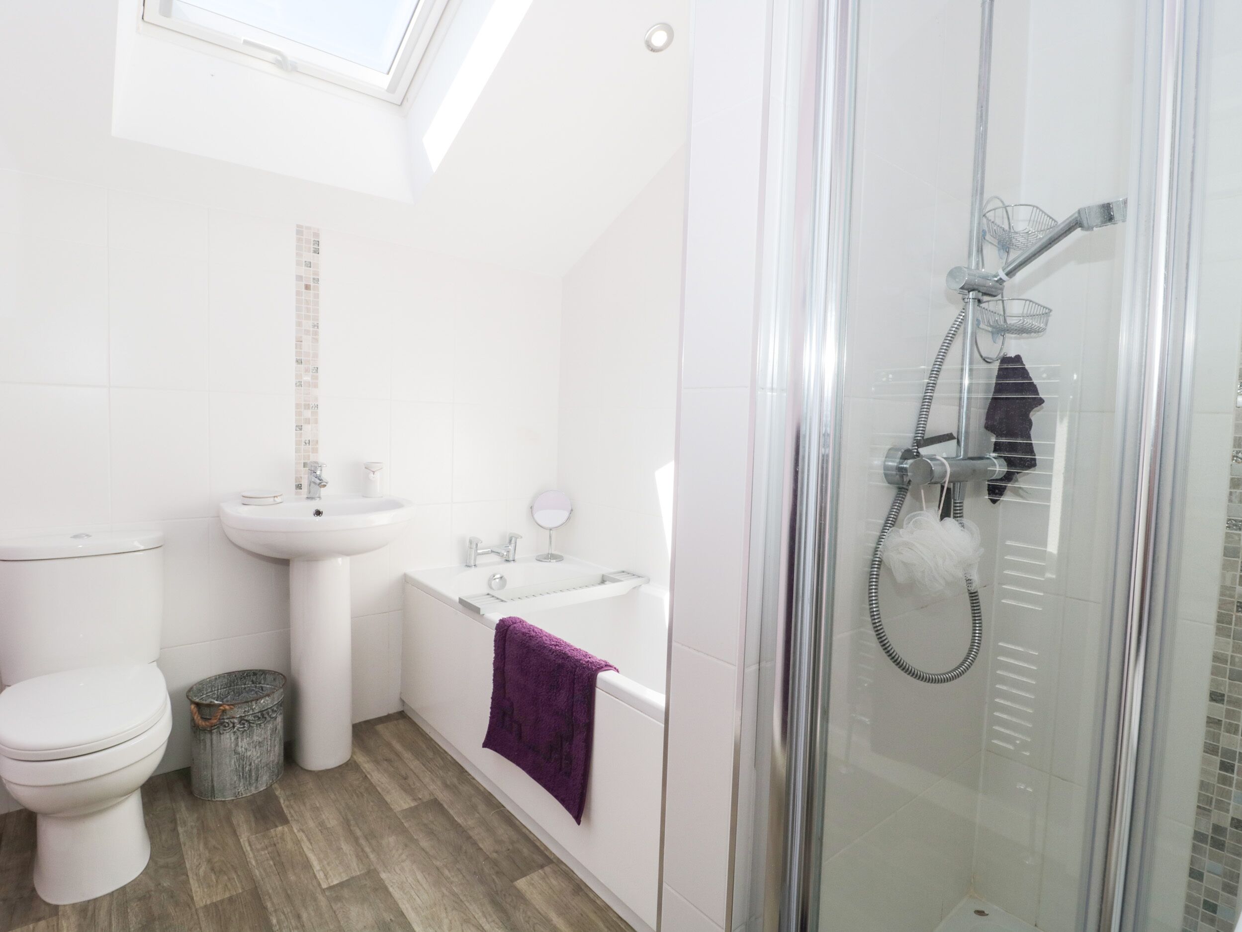 A bathroom with a toilet, sink, bathtub, and shower.