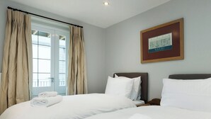 A hotel room with two beds, a window with curtains, and a framed map on the wall. - 2 bedroom accommodation in Duke Street (Duke Street)