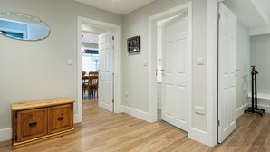 A hallway with wooden flooring, white doors, and a wooden cabinet. - 2 bedroom accommodation in Duke Street (Duke Street)