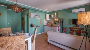 Un espacio habitable compacto con comedor, kitchenette y sofá.