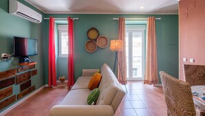 Un salon avec un canapé, un téléviseur et des éléments de décoration fixés au mur.