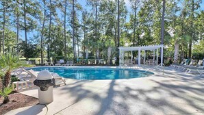 A swimming pool with lounge chairs and a covered seating area surrounded by trees. - New 2BR condo on 18th hole near beaches & ALL sports arenas—perfect getaway (Myrtle Beach)