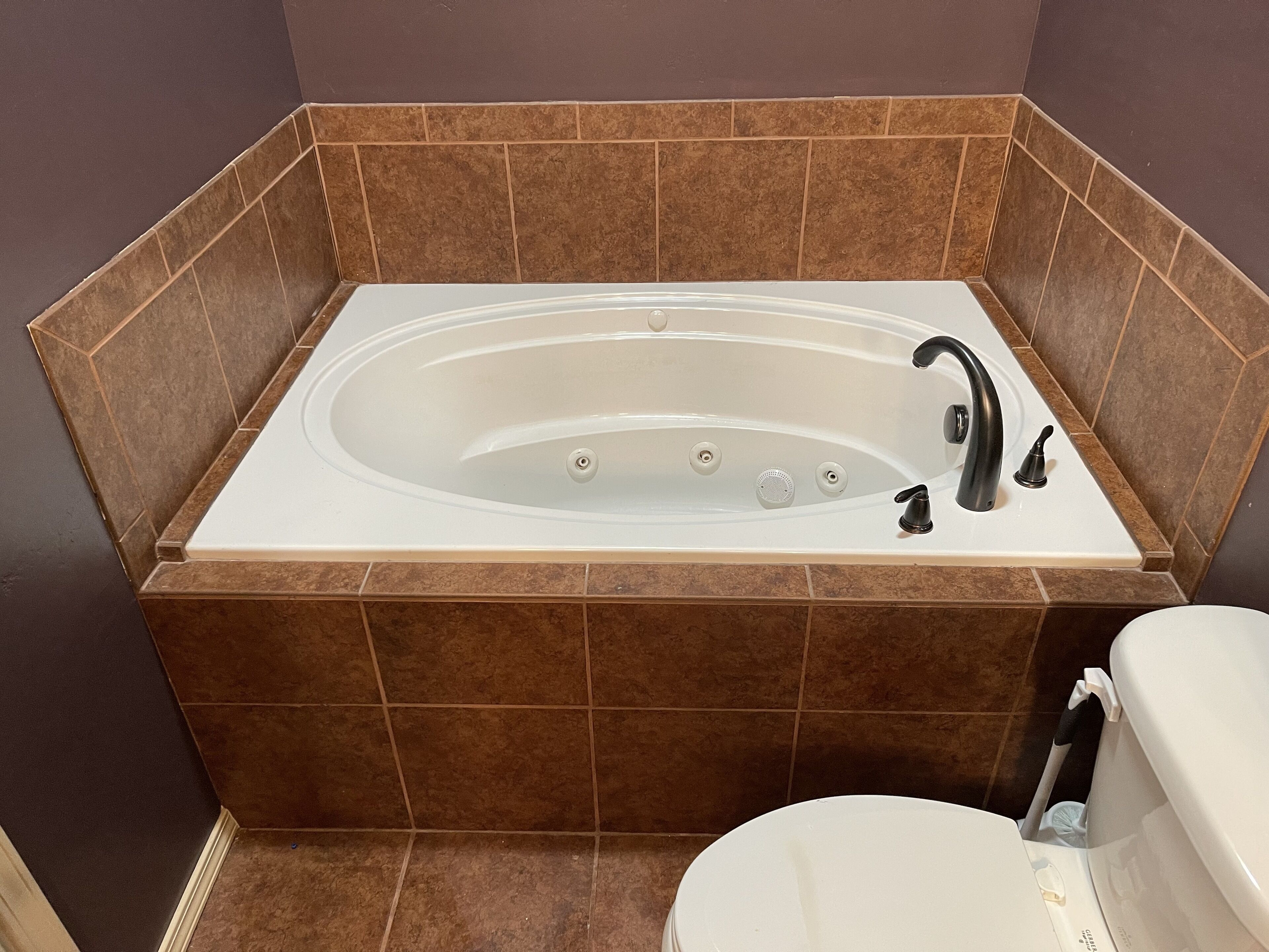 Un baño con bañera independiente, inodoro y zona de ducha.