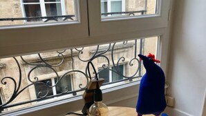 Ein runder Holztisch mit einer dekorativen Leuchte und einer blauen Spielzeugfigur mit roten Füßen.