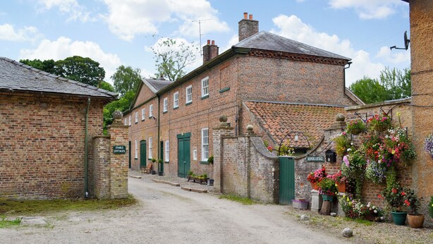 A brick building with a sign reading 'Stable Cottages.' - 3 bedroom accommodation in Rudston, near Bridlington (Rudston, near Bridlington)