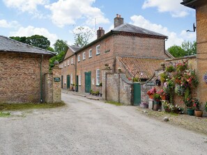 A brick building with a sign reading 'Stable Cottages.' - 3 bedroom accommodation in Rudston, near Bridlington (Rudston, near Bridlington)