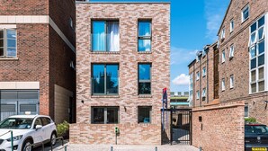 A modern building with a brick facade, large windows, and a visible entrance gate. - Bootham Row Hideaway -  a couples retreat that sleeps 2 guests  in 1 studio (York)