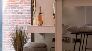 Eine moderne Küche mit Backsteinwand, weißer Arbeitsplatte und einer Bar mit Barhocker.
