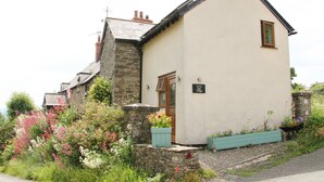 A cottage with a stone facade, a wooden door, and a sign indicating it is a 'Linker Lane Cottage'. - Linley Lane Cottage (Bishops Castle)