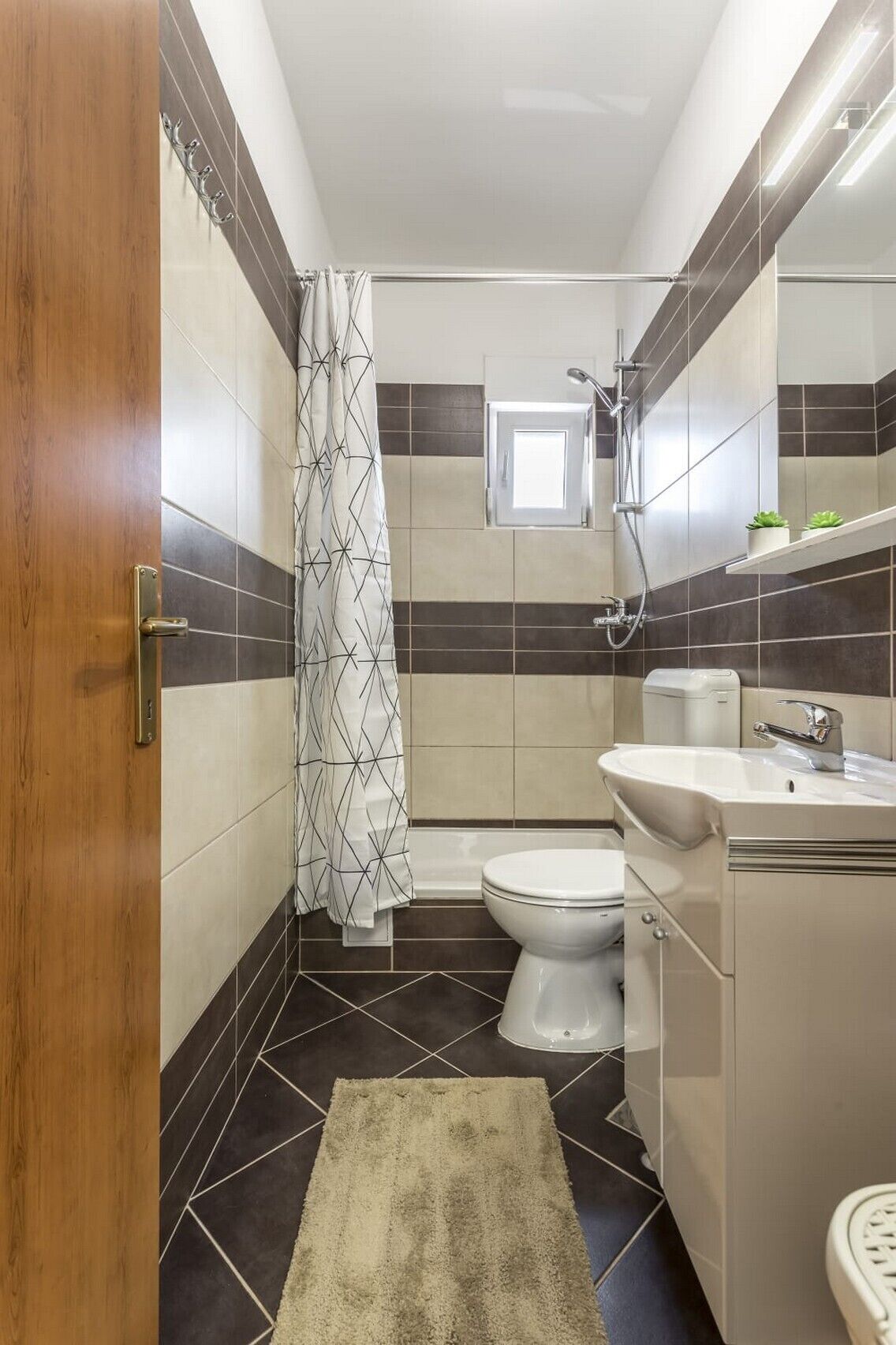 A compact bathroom with a shower, toilet, and sink.