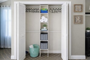 A walk-in closet with shelves, hanging space, and a laundry basket.