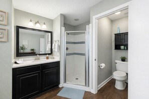 A bathroom with a shower, toilet, and vanity. - Canal-Front Retreat, Walk to Beach, Dock (Navarre)