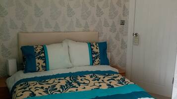 Un dormitorio con cama, almohadas y una puerta.