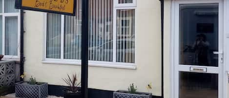 Een gebouw met een bordje voor 'Three B's Bed & Breakfast' en een bord 'Geen reclamefolders'.