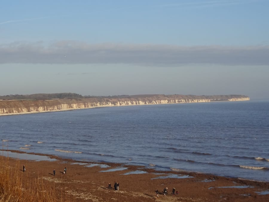 Een kustlandschap met kliffen en een strand.