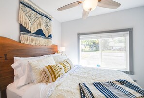 A bedroom with a wooden headboard, a large window, and a ceiling fan. - French Toast Flat (Moscow)