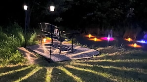 Un banc dans un parc, la nuit, avec des lumières en arrière-plan.