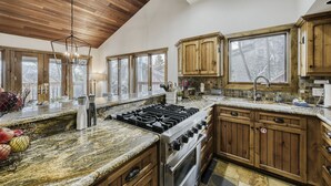 A kitchen with wooden cabinets, a gas stove, and a large window.