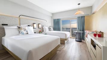 A hotel room with two beds, a balcony, a dining area, and a view of the sky.